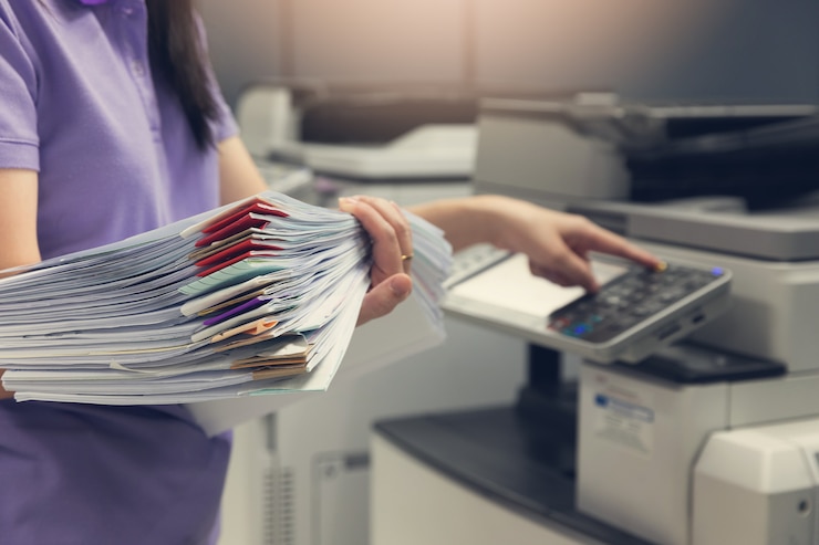 Foto bussinesswoman die kopieerapparaatmachine gebruiken om administratie te kopiëren.