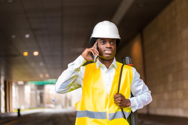 Busy african architect using phone and walking along the city