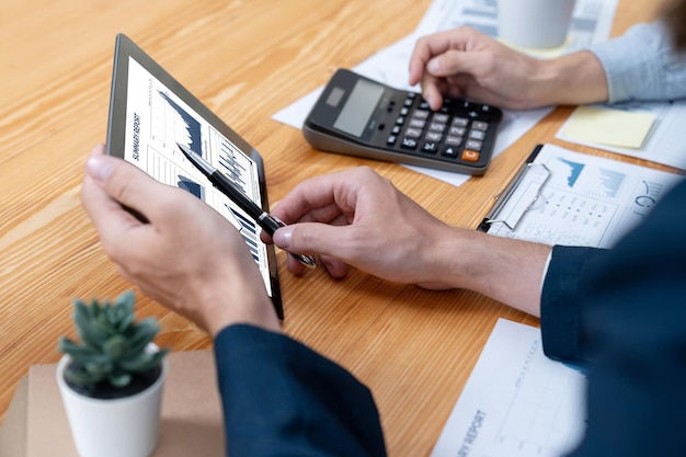 Busy analyst team in office analyzing financial data analysis by tablet Entity