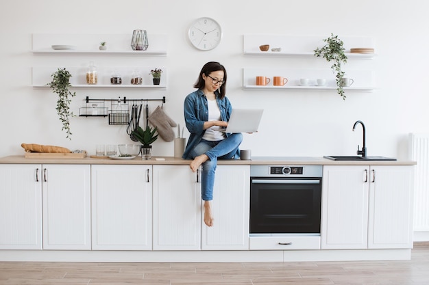 Busy asian woman teleworking via laptop in apartment