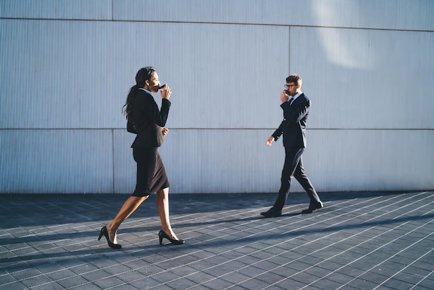 Busy business people with coffee walking on street