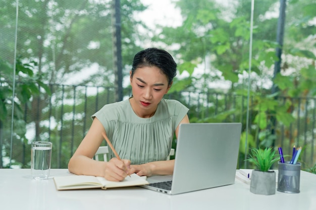 Busy businesswoman writing in an agenda on a desktop at office