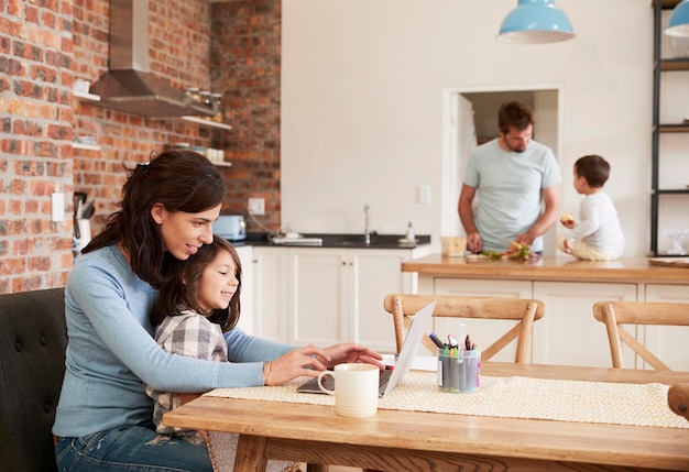 busy family home with mother working as father prepares meal