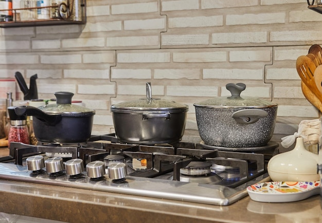 Busy Kitchen Scene with Pots Lids and Gas Stove Cooking Food at Home