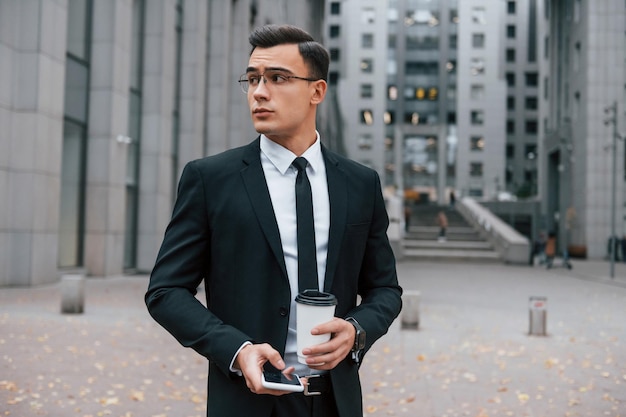 Busy man Businessman in black suit and tie is outdoors in the city