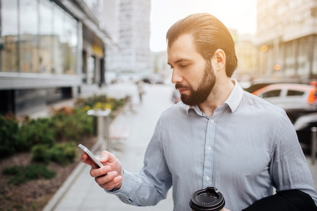 L'uomo impegnato ha fretta, non ha tempo, parlerà al telefono mentre è in movimento. uomo d'affari che fa più compiti. uomo d'affari multitasking.