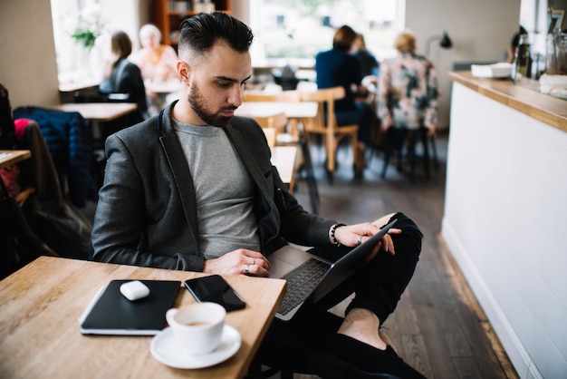 Busy man with laptop working in cafe