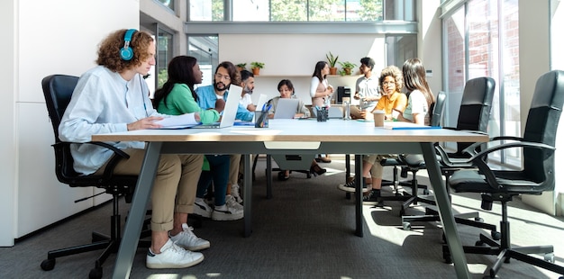 Photo busy office multiracial coworkers share big table in coworking space horizontal banner image