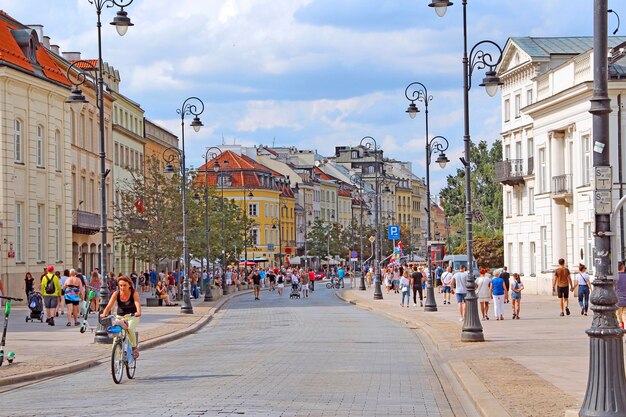 Busy street with pedestrians and cyclists in warsaw beautiful urban panorama urban life panoramic urban view woman driving bicycle along city street urban transport