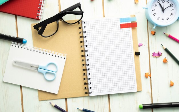 Busy student's desk with blank open notebook