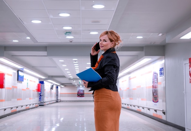 Busy Woman CEO manager in hall of business building using phone and checking document file.Business Woman in modern hallaway going to work