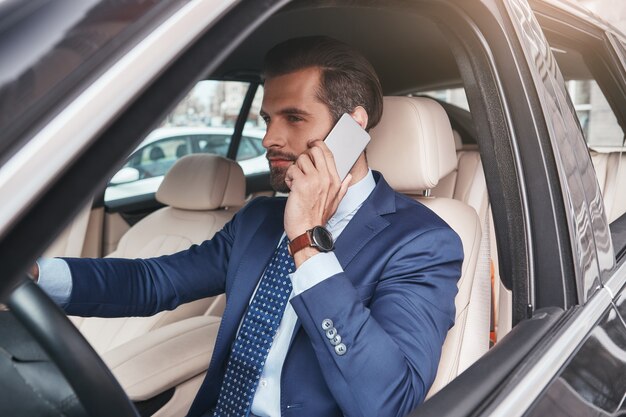 Busy working day side view of stylish and confident bearded businessman in formal wear is