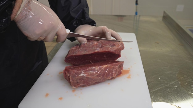 肉屋は精肉店で鋭いフィレナイフで新鮮な牛肉をカットします