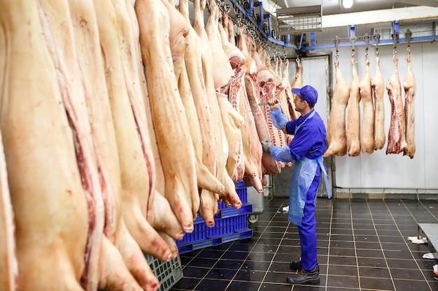 Butcher cutting pork  at the meat manufacturing.