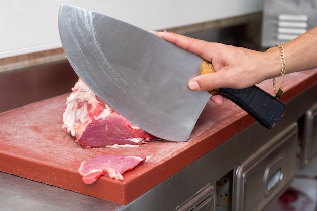 Butcher cutting steaks at the butcher shop