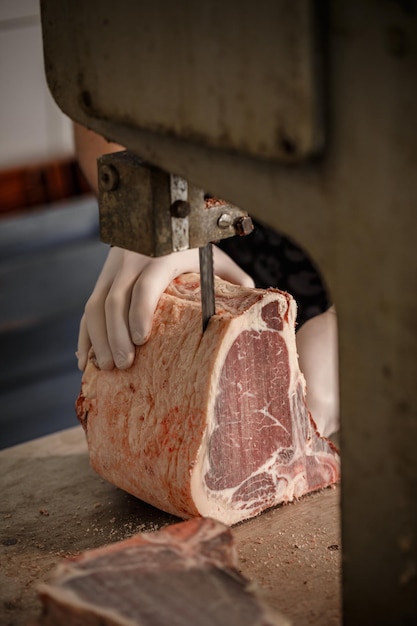 Butcher is slicing beef meat