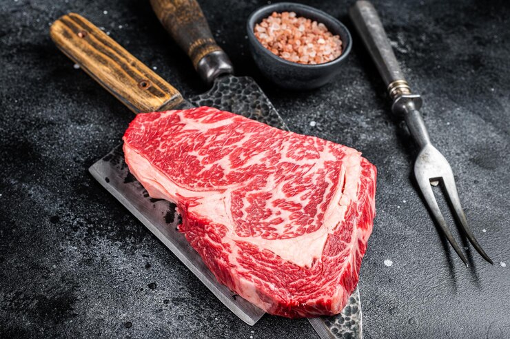 和牛リブアイ ステーキ生牛肉肉と肉屋のテーブル黒背景トップ ビュー