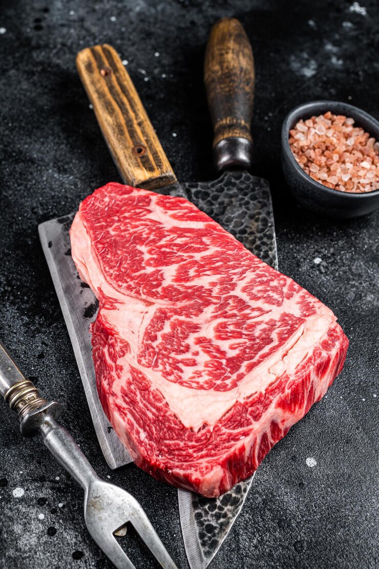 和牛リブアイ ステーキ生牛肉肉と肉屋のテーブル黒背景トップ ビュー