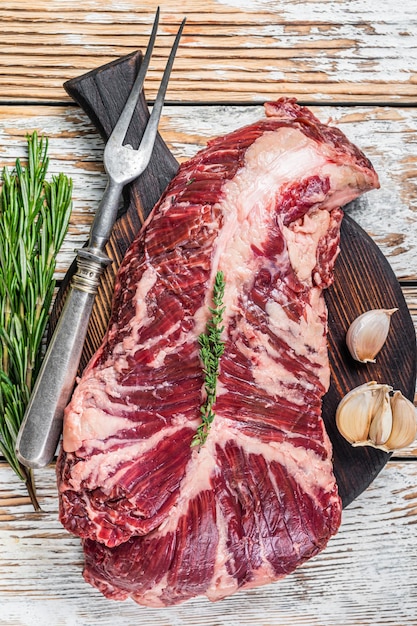 Butchers choice steak Onglet Hanging Tender beef meat on a cutting board. White wooden background. Top View.