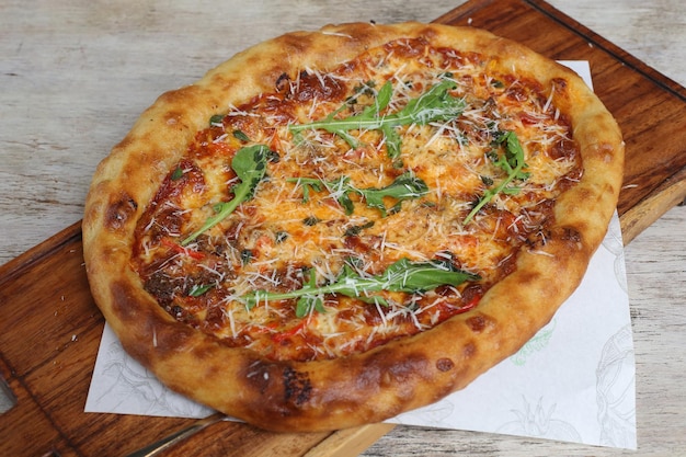 Butchers crispy stone fried pizza served in a cutting board isolated on grey background side view