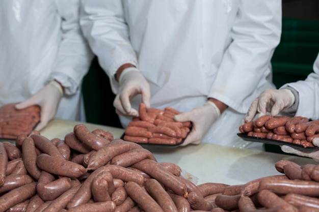 Butchers packing raw sausages