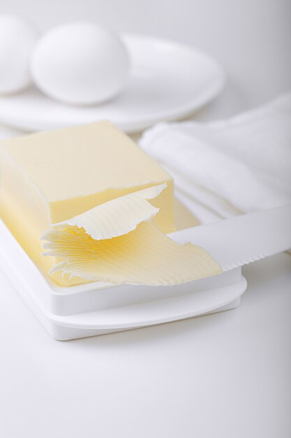 Photo butter, chicken eggs on a white table. light background.