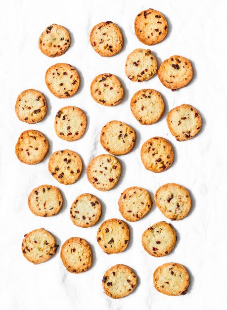 Butter cookies with dried cranberries and peanuts on a light background top view