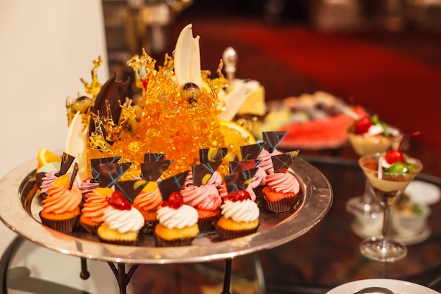 Butter Cream Cupcakes Assortment on silver tray with candy art decor.