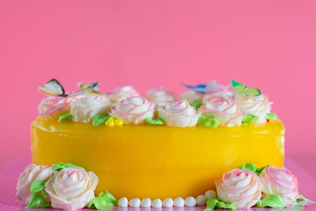 Photo butter cream of pink roses decorated on orange pond cake on pink background