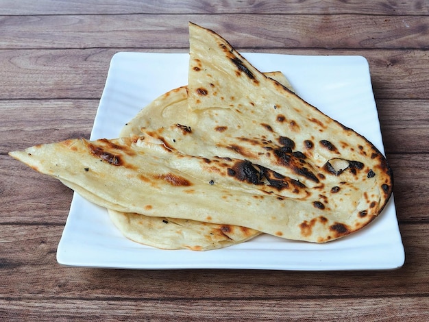 Butter naan isolated over a rustic wooden background selective focus