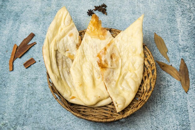 Butter Naan with chili sauce served in a basket isolated on grey background top view of bangladesh food