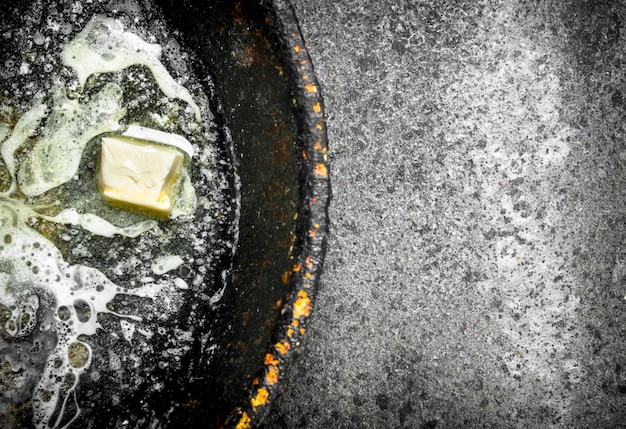 Butter in an old pan. On rustic background.