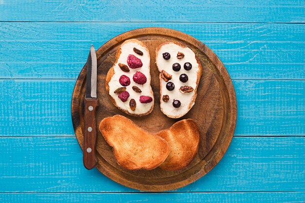 Butter sandwiches on healthy wholewheat bread topped with fresh raspberries, currants and raisins. top view. still life. space for text