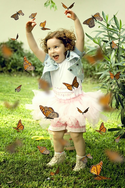 Butterflies flying around happy baby girl in garden