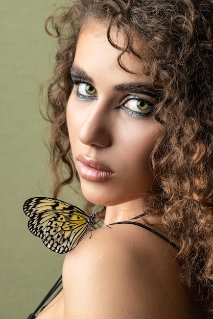 Butterfly on the girl face green background