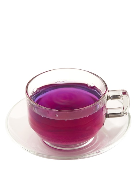 Butterfly pea tea in glass with coaster isolated on white background blue hot drink Butterfly pea tea changes its color from blue to purple by mixing lemon juice Thai herbal tea