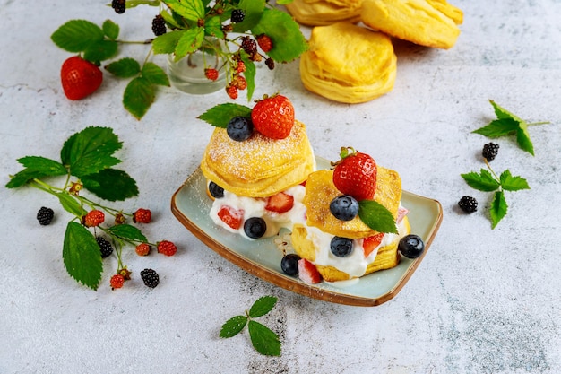 Buttermilk biscuit in plate with berries.