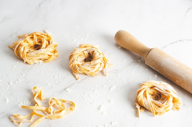 Butternut squash noedels in een pasta maker machine op marmeren achtergrond.
