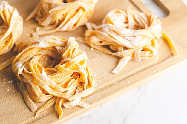 Butternut squash noodle nests on a wooden board on marble background.