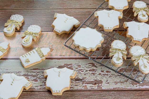 Buttery biscuits covered with royal icing. in the form of a baby bodysuit, a bottle and a rattle.