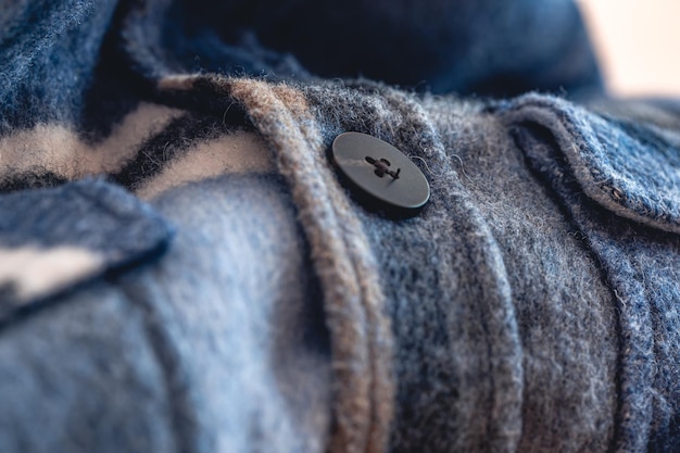 Button on a warm blue shirt macro shot