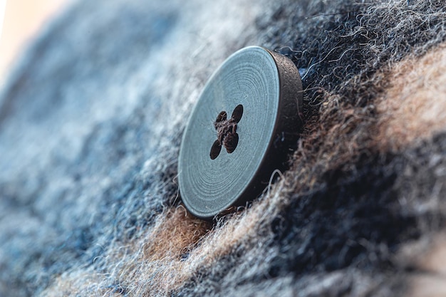 Button on a warm blue shirt macro shot