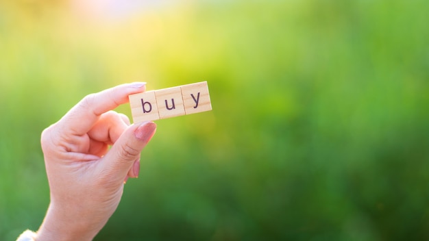 "BUY" alphabet in woman hand.