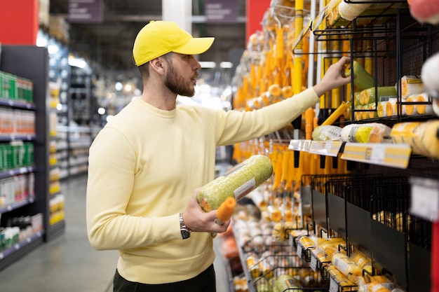 The buyer chooses brushes and rollers in the repair goods store