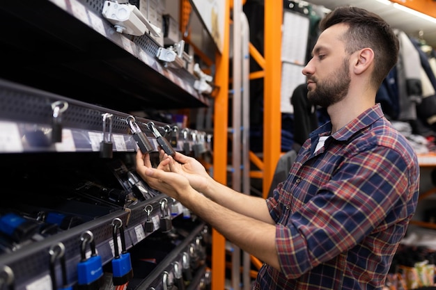 The buyer chooses a padlock for home in the store