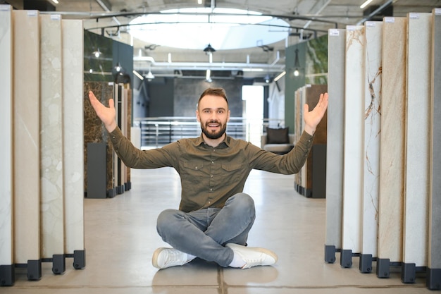 Photo buyer examines ceramic tiles in a construction store