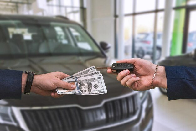 The buyer pays a large sum of dollars for the purchase of a car in one of the city's showrooms The concept of a new grand purchase