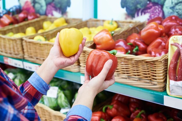 Buyer selects the bell peppers in the store