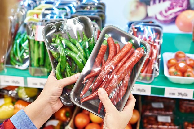 Buyer selects the chili peppers in the store