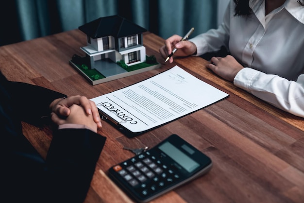 Buyer signs the loan contract paper with a pen on the desk Enthusiastic